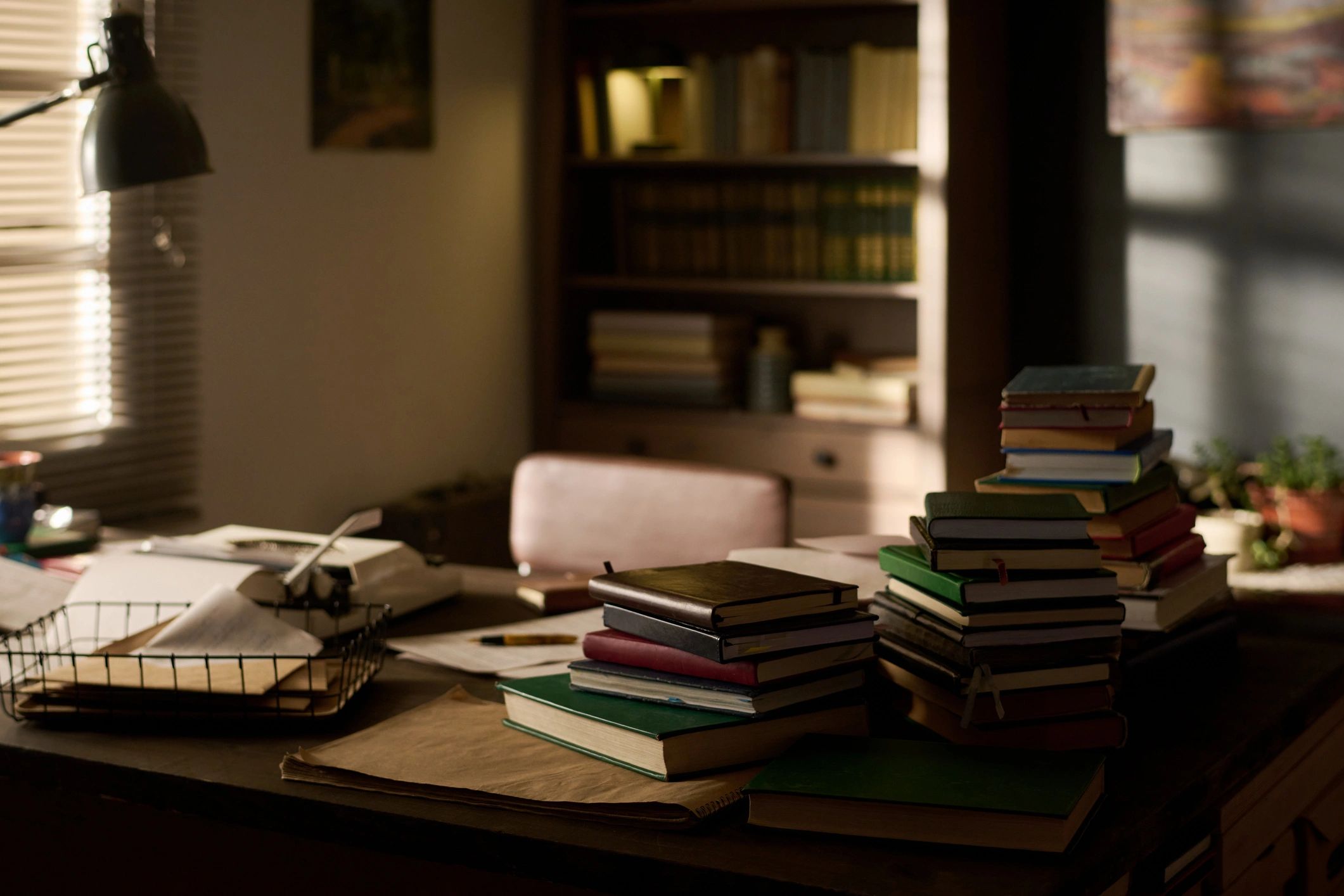 Stack of Books Arranged on Desk in Sunlit Home Office Interior Setting